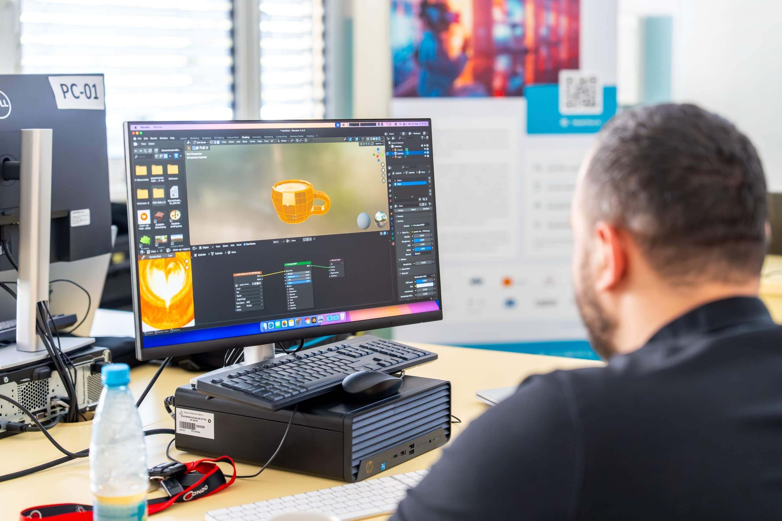 Udeleženec na računalniku v programu Blender, opremlja skodelico kave z zlatimi teksturami.