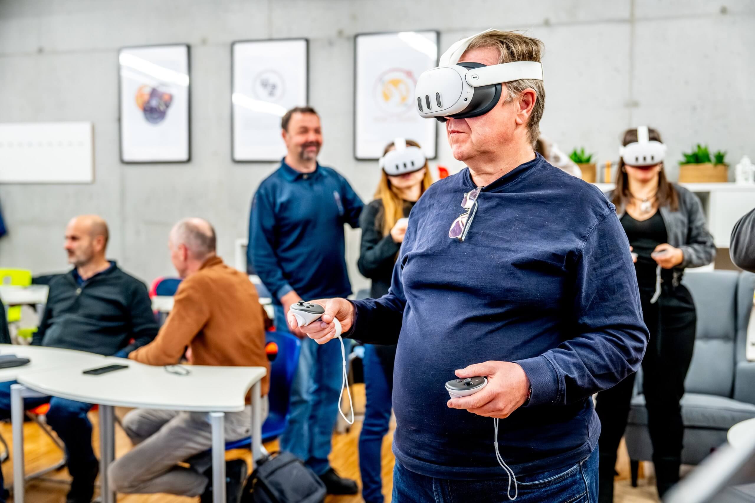 Udeleženci izobraževanja v Kranju med preizkušanjem očal za navidezno resničnost.