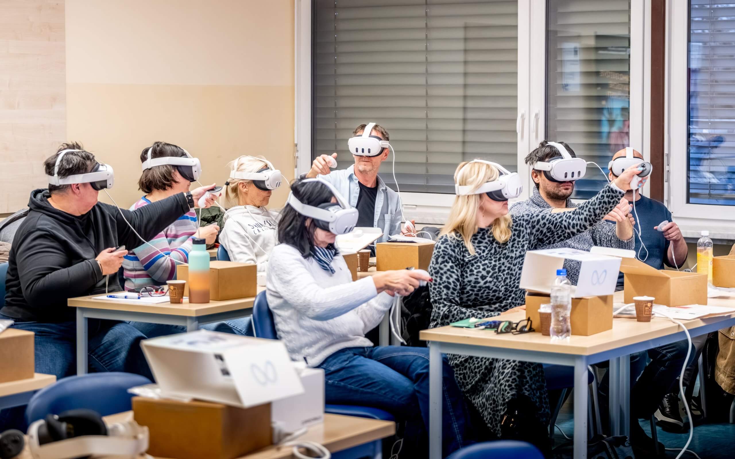 Predavatelj razlaga delovanje aplkiacije uporabniku, ki ima na glavi virtualna očala in v rokah krmilnike.